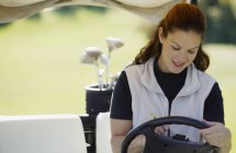 Retrato de golfista bastante femenina en coche de golf - foto de stock