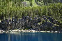 Горное озеро с скалистой скалой — стоковое фото