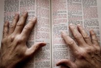 Руки на відкритій Біблії — стокове фото