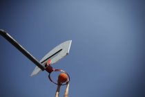 Низький кут зору людини, що грати в баскетбол проти синього неба — стокове фото