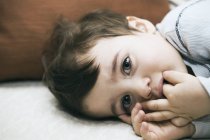 Adorable Toddler Boy Lying Down And Looking At Camera — Stock Photo