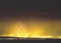 Молния над современным городом — стоковое фото