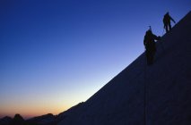 Альпинисты карабкаются по склону — стоковое фото