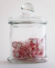 Caramelle alla menta piperita in vaso di vetro su sfondo bianco — Foto stock