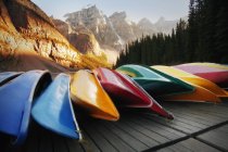 Canoe multicolore che poggiano sul molo — Foto stock
