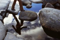 Reflection Of hiker Crossing  Stream — Stock Photo