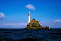 Lighthouse on rock in water — Stock Photo