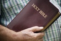 Людина в сорочці тримає Біблію — стокове фото