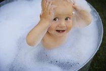 Bebê caucasiano feliz na bacia de lavagem — Fotografia de Stock