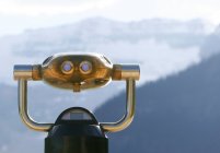 Binóculos para uma visão mais próxima da paisagem na frente de montanhas enevoadas — Fotografia de Stock