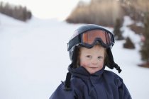 Um menino jovem vestindo um capacete e máscara de esqui; Veado Vermelho, Alberta, Canadá — Fotografia de Stock