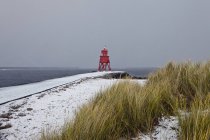 Roter Leuchtturm an der Küste — Stockfoto