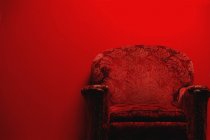 Vintage armchair in front of red background with copy space — Stock Photo