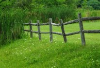 Деревянный забор на траве — стоковое фото