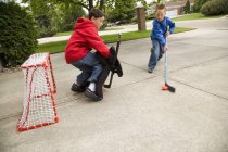 Two caucasian boys playing in street hockey — Stock Photo
