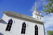 Iglesia blanca contra el cielo azul - foto de stock
