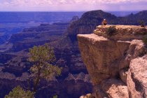 Person sitzt auf Felsvorsprung — Stockfoto