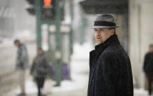 Uomo vestito di grigio Trilby e cappotto scuro — Foto stock