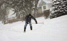 Uomo con pala compensazione neve su strada — Foto stock