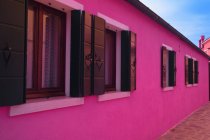 Рожевий будинків з windows — стокове фото