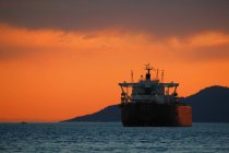 Freighter in ocean during sunset — Stock Photo