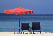 Стулья и зонтик на пляже — стоковое фото