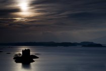 Замок на маленьком острове над водой — стоковое фото