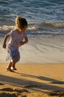 Дівчина біжить піском — стокове фото