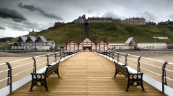 Wooden pier with benches — Stock Photo