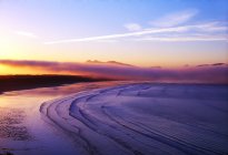 Praia de areia com água ondulada — Fotografia de Stock