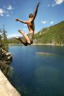 Saltar alto en el lago - foto de stock