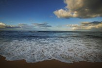 Paisaje marino con olas sobre arena - foto de stock