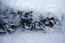 Primeras heladas patrón de invierno en la ventana - foto de stock
