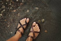 Sandaled ноги на берегу — стоковое фото