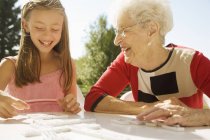 Nonna e nipote giocare domino gioco insieme — Foto stock