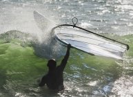 Man in water holding onto windsurfing board. Tarifa, Cadiz, Andalusia, Spain — Stock Photo