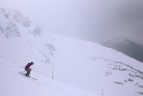 Downhill Skiier on snow slope — Stock Photo