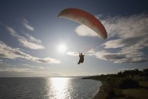 Homme parapente au-dessus de l'eau à la périphérie de Victoria, Colombie-Britannique, Canada — Photo de stock