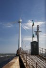 Turbine eoliche su un molo lungo la costa — Foto stock