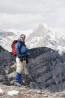 Hombre de pie en la cima de una montaña - foto de stock