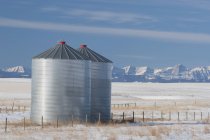 Metal Grain Bins In Snowy Field — Stock Photo