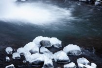 Rochas cobertas de neve em águas rasas — Fotografia de Stock