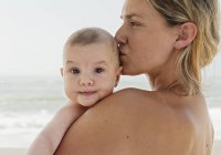 Mother Holding Her Baby Close With Kiss — Stock Photo