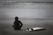 Серфер сидить на пляжі — стокове фото