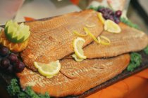 Pesce guarnito con fette di limone — Foto stock