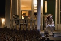 Donna seduta fuori dalla sua casa — Foto stock