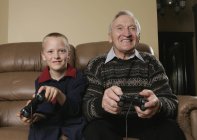 Grand-père et petit-fils jouant à un jeu — Photo de stock