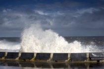 Wellen krachen gegen Barriere — Stockfoto