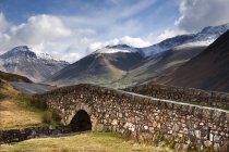 Puente de piedra en paisaje de montaña - foto de stock
