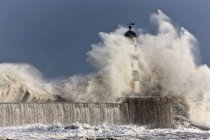 Волны разбиваются о маяк — стоковое фото